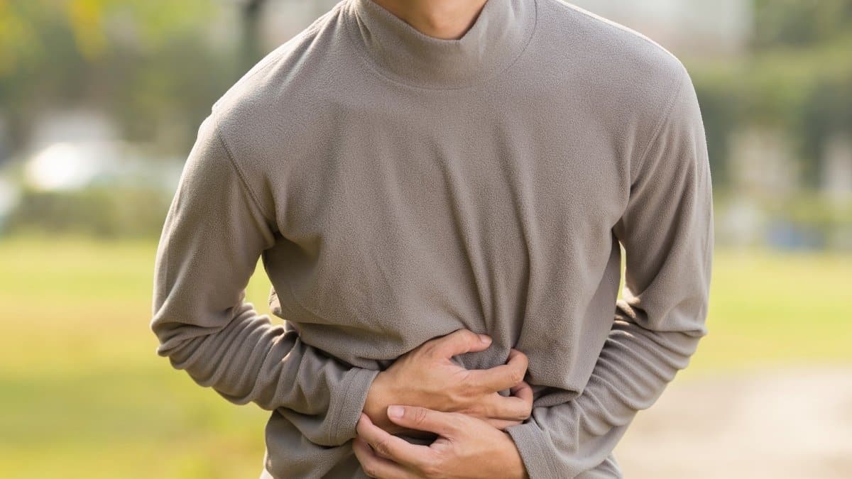 A man holding his stomach due to pain caused by indigestion