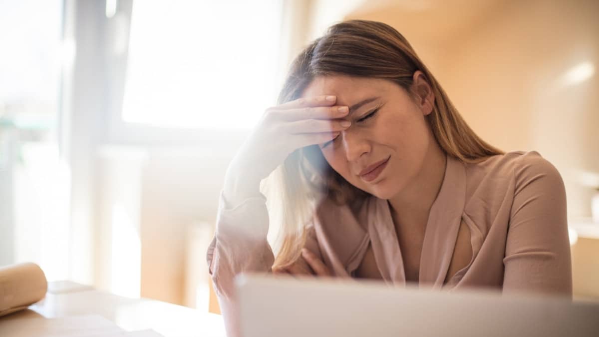 A woman is frustrated with everyday headaches that might be migraine