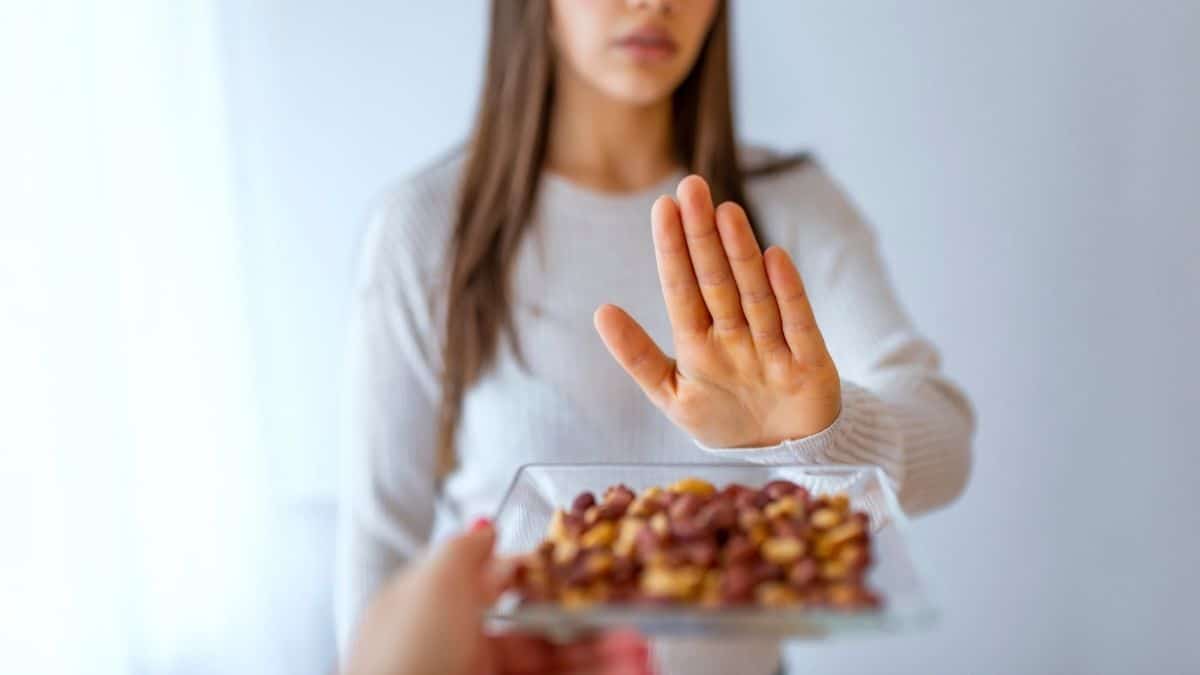 A woman saying 'no' to peanuts due to her food allergies