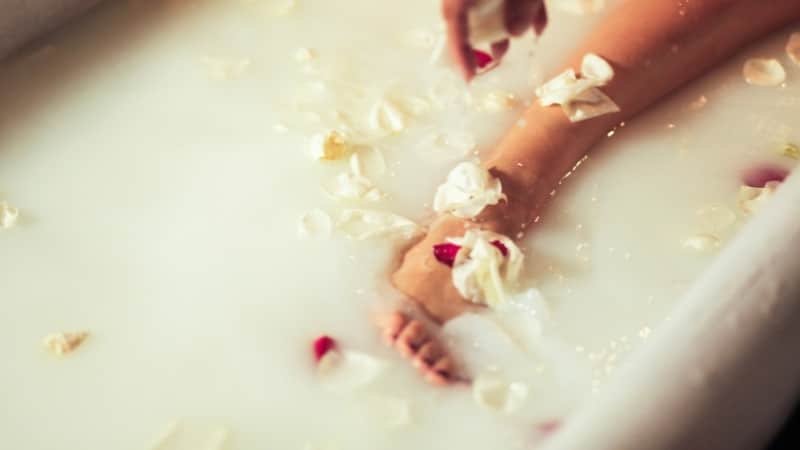 milk in a bath tub with flower petals