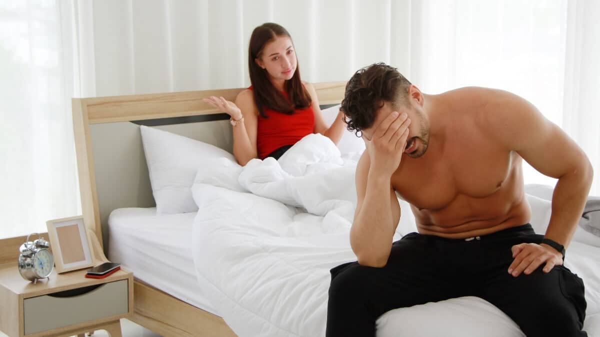 worried man sits on bed with partner