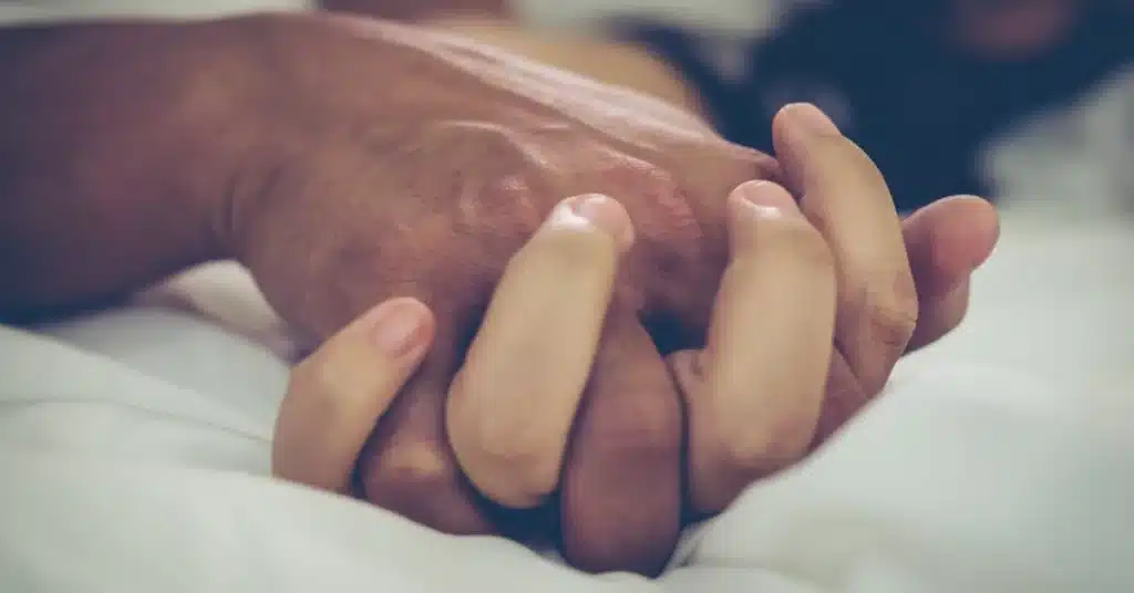 a couple holding hands while having sex