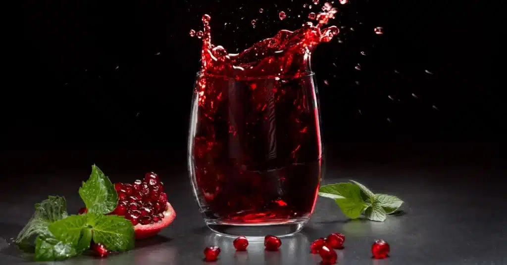 Pomegranate juice glass with black background