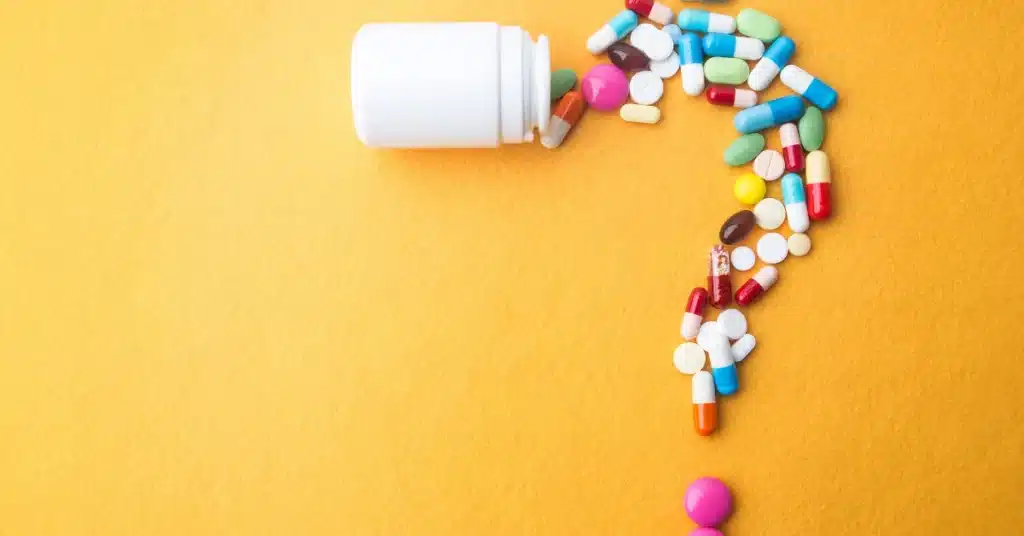 Multiple pills falling out of a bottle