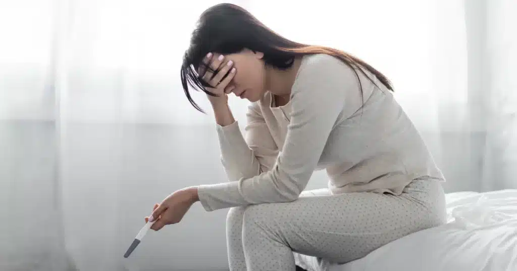 Sad Woman Holding Pregnancy Test With Negative Result