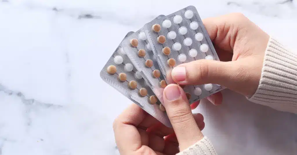Birth control pills in woman's hands